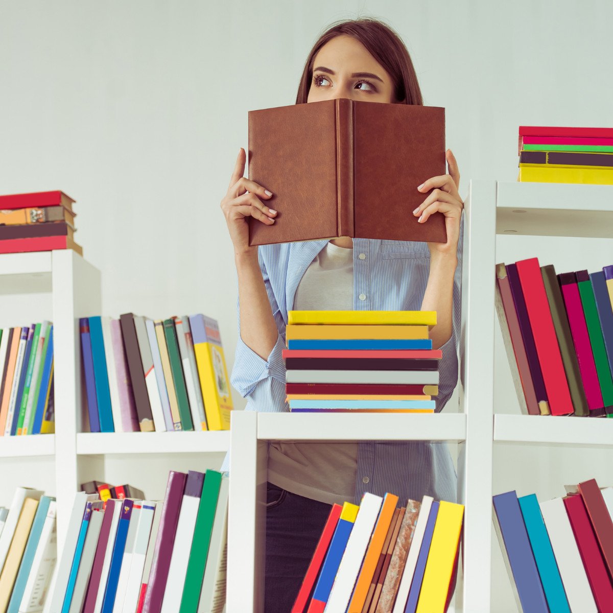 woman with book and bookshelves.