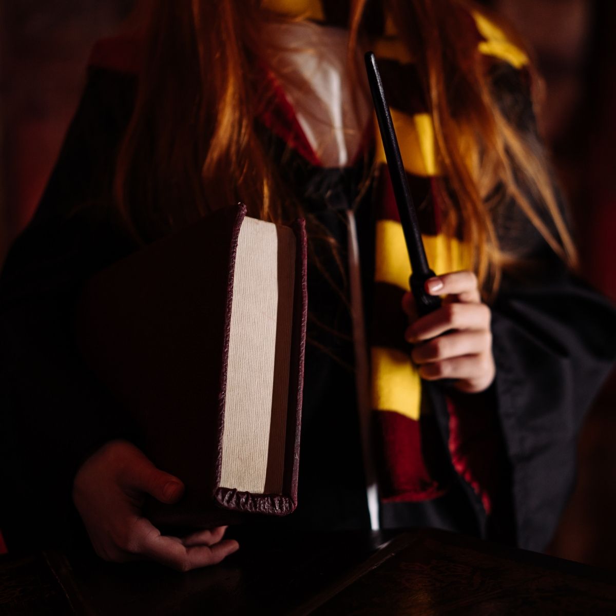 girl dressed as harry potter holding a book.