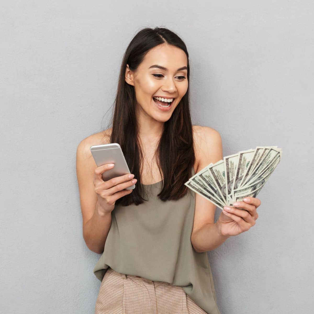 woman holding cell phone and money.