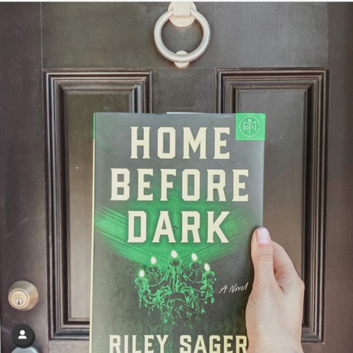 home before dark by riley sager in front of front door.