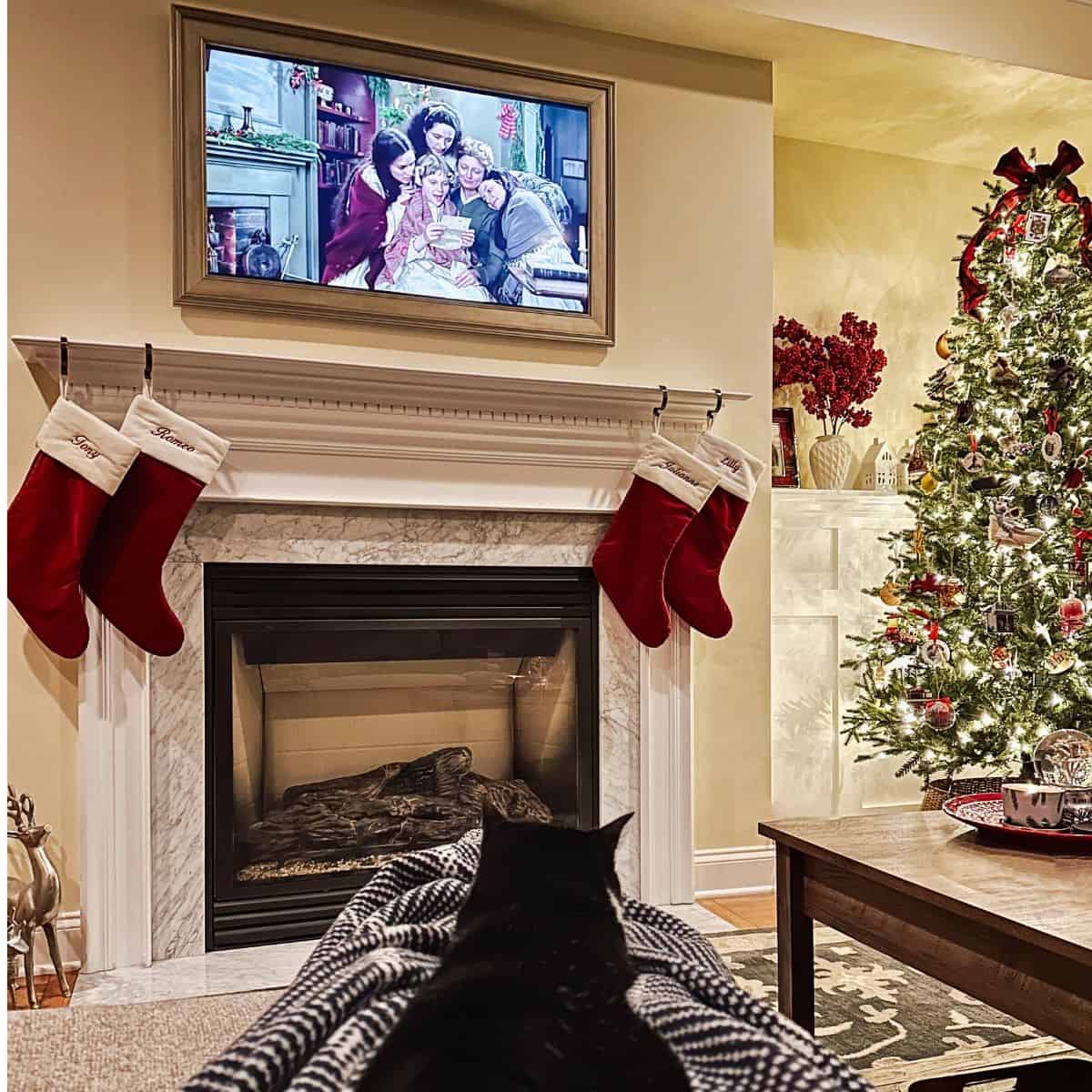 little women playing on tv near a christmas tree.