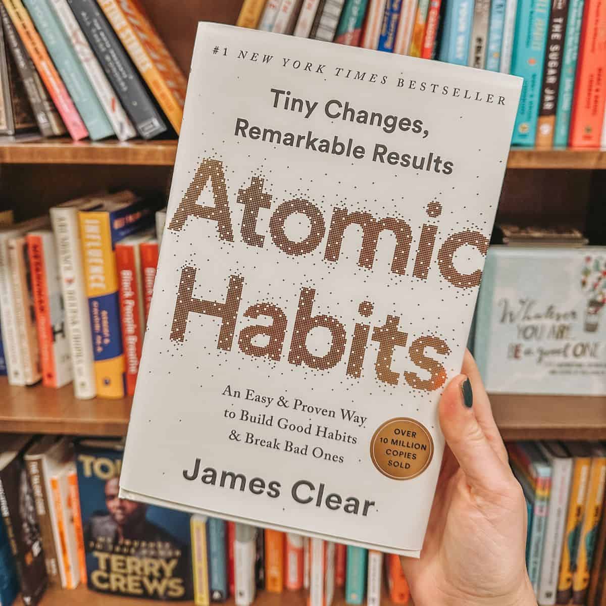 atomic habits by james clear in front on bookshelves.