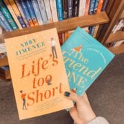 books by abby jimenez in front of bookshelves.