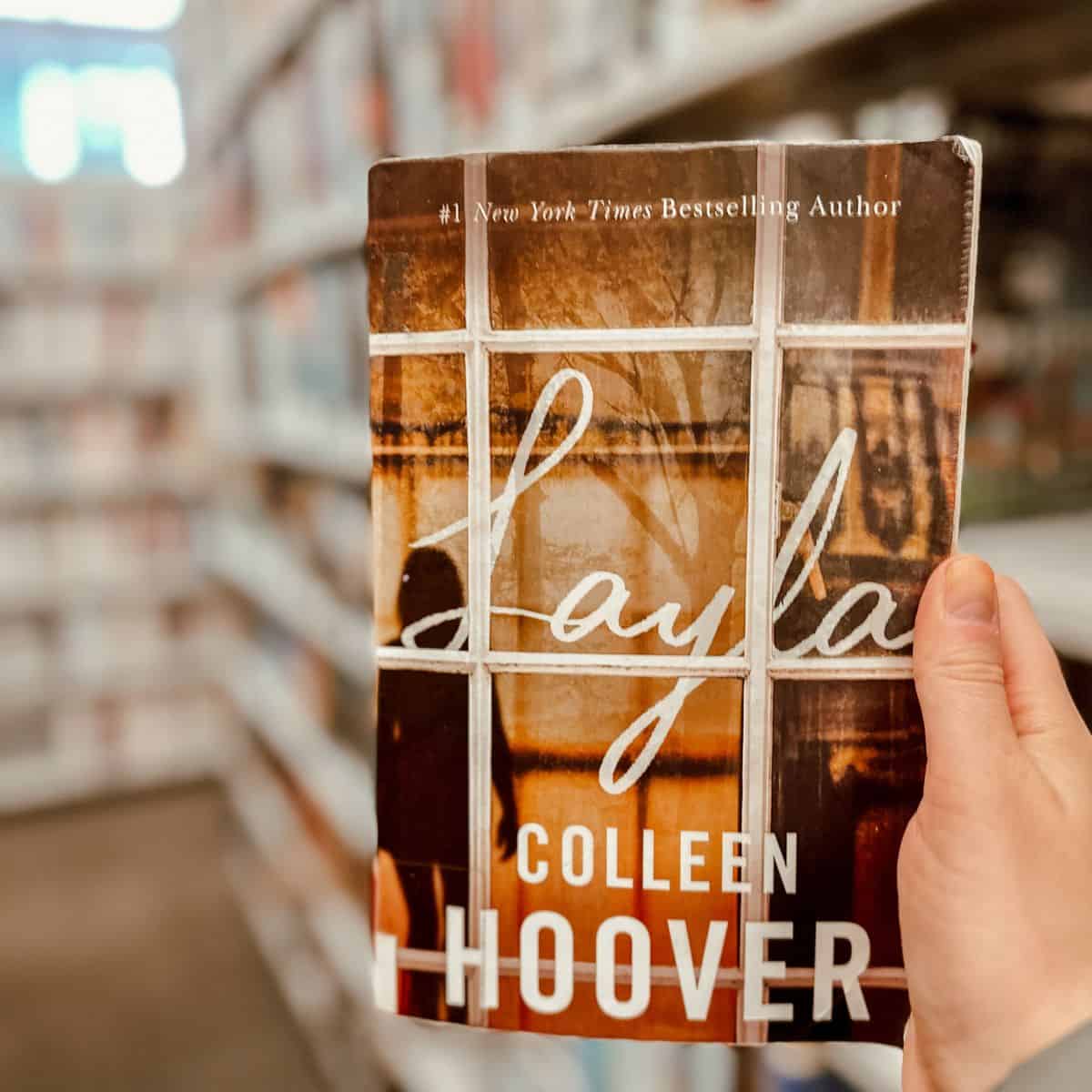 layla by colleen hoover in front of bookshelves.