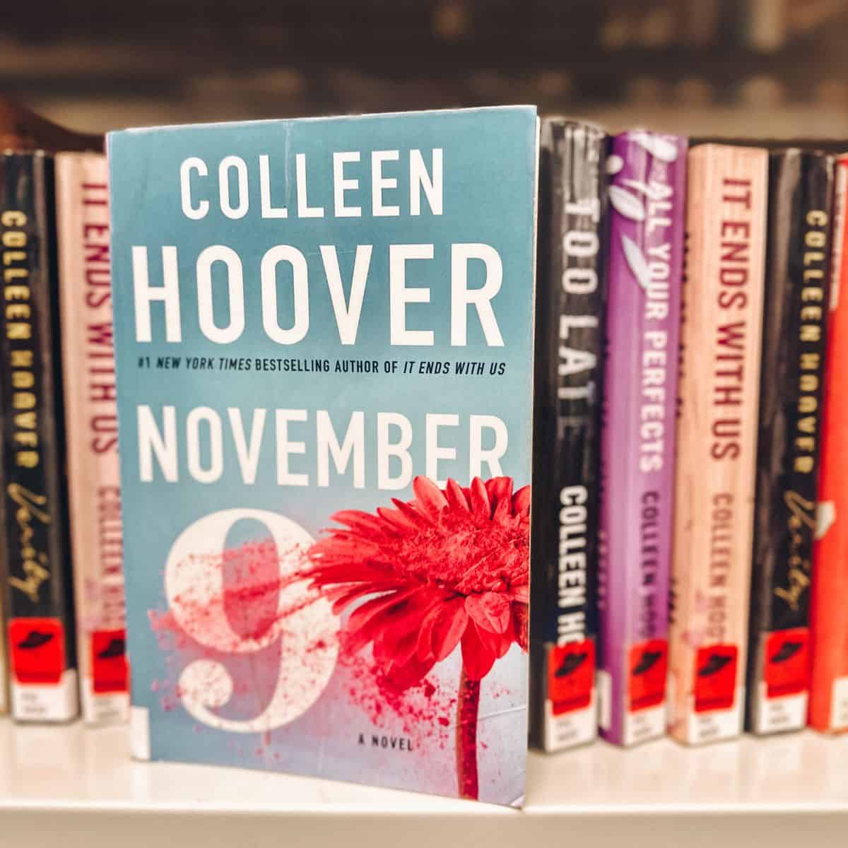 november 9 by colleen hoover in front of bookshelves.