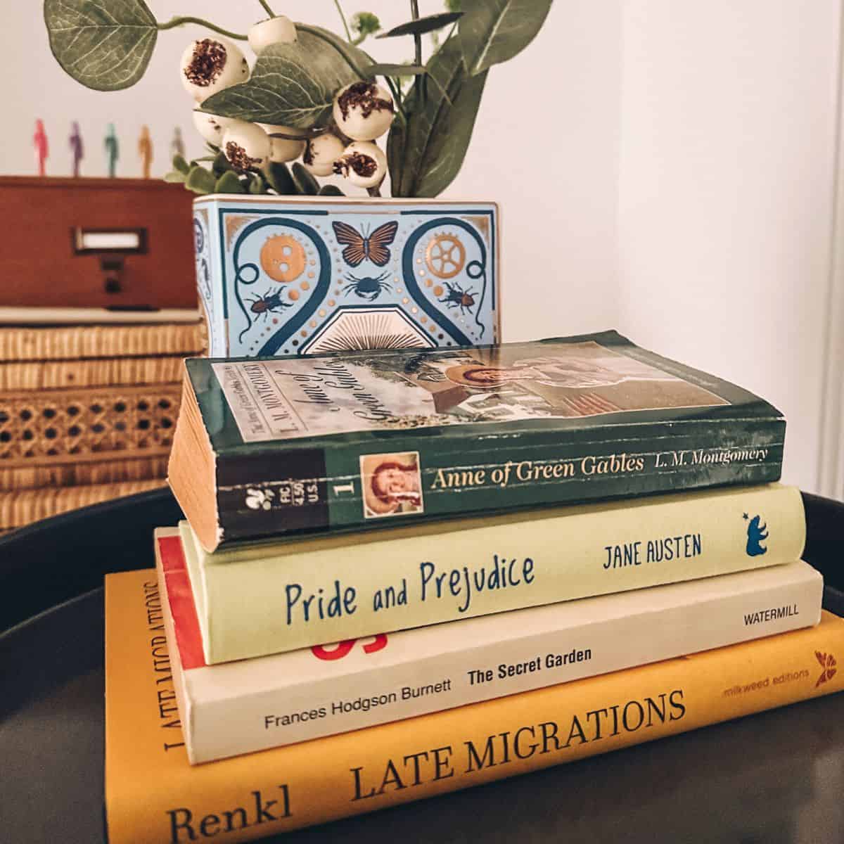 stack of spring books with a flower in a vase.