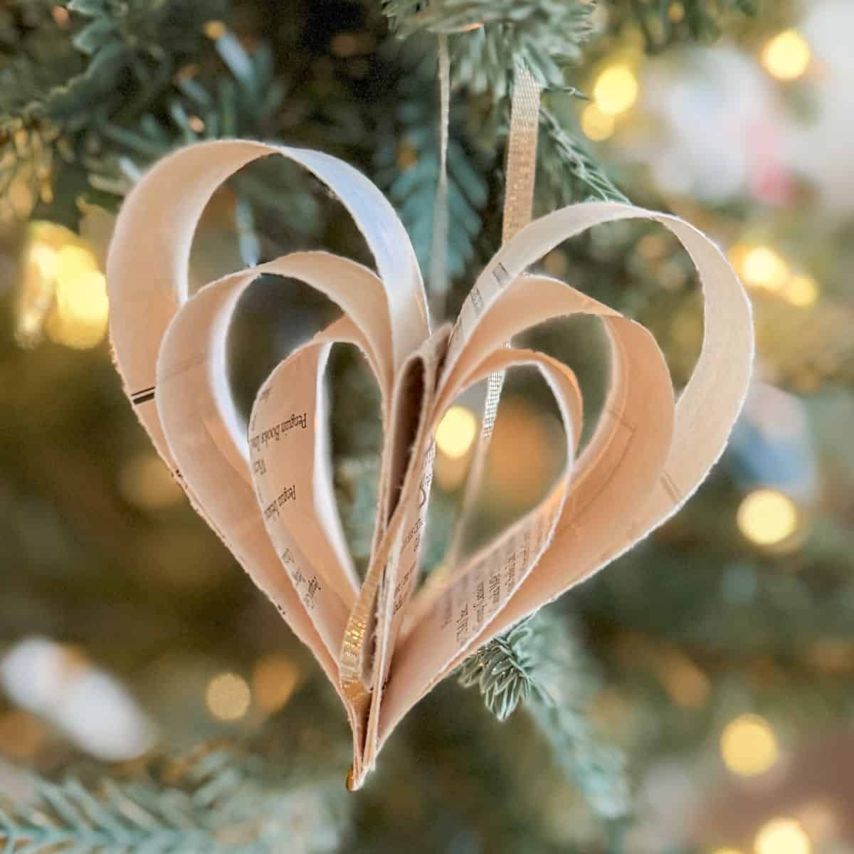 heart ornament made from a book page on a tree.