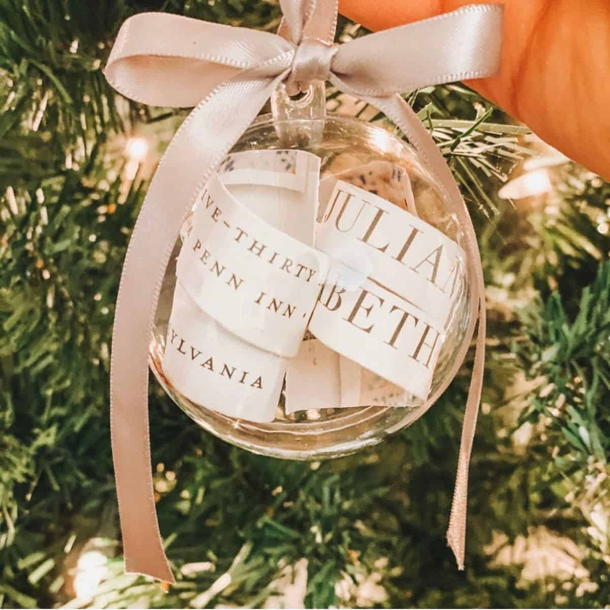 DIY wedding invitation ornament in front of a tree.