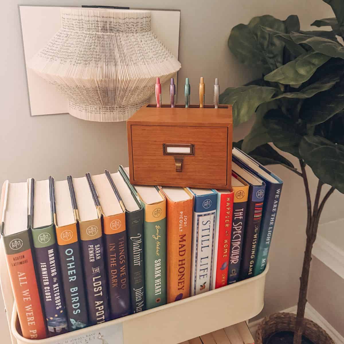 my collection of library themed merch: a book card, library card catalog, and book art.