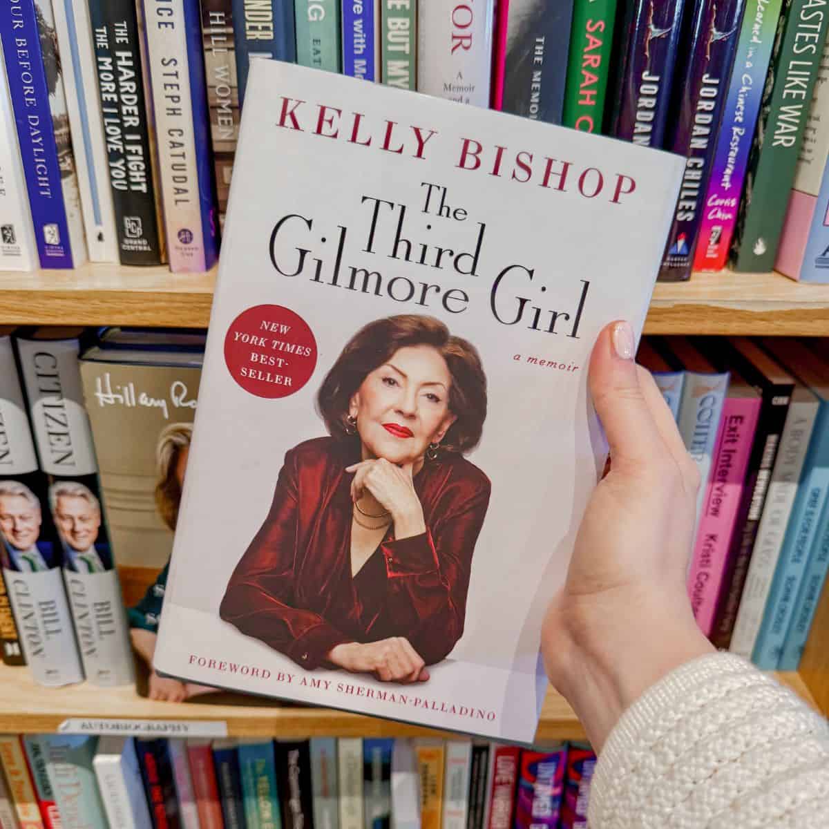the third gilmore girl by kelly bishop in front of a bookshelf.