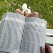 woman reading summer quotes from a book outside.